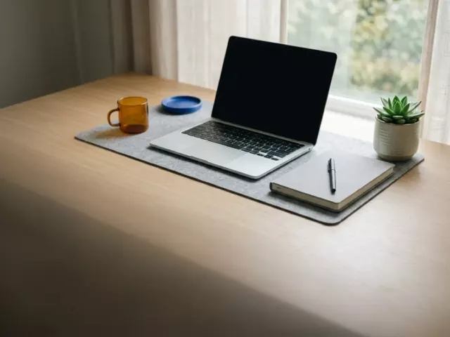 Bureau moderne avec ordinateur portable, carnet et plante près d'une fenêtre