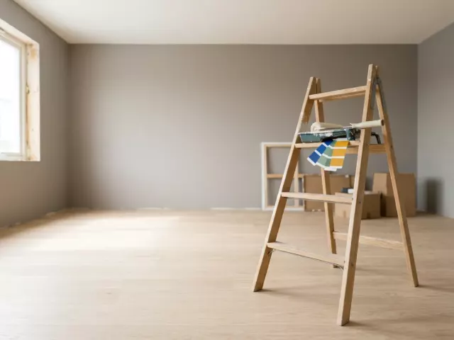 Salon lumineux en finition avec parquet clair et mur fraîchement peint