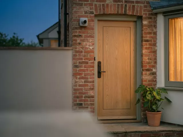 Porte d'entrée avec serrure de sécurité et caméra discrète sur un mur en briques